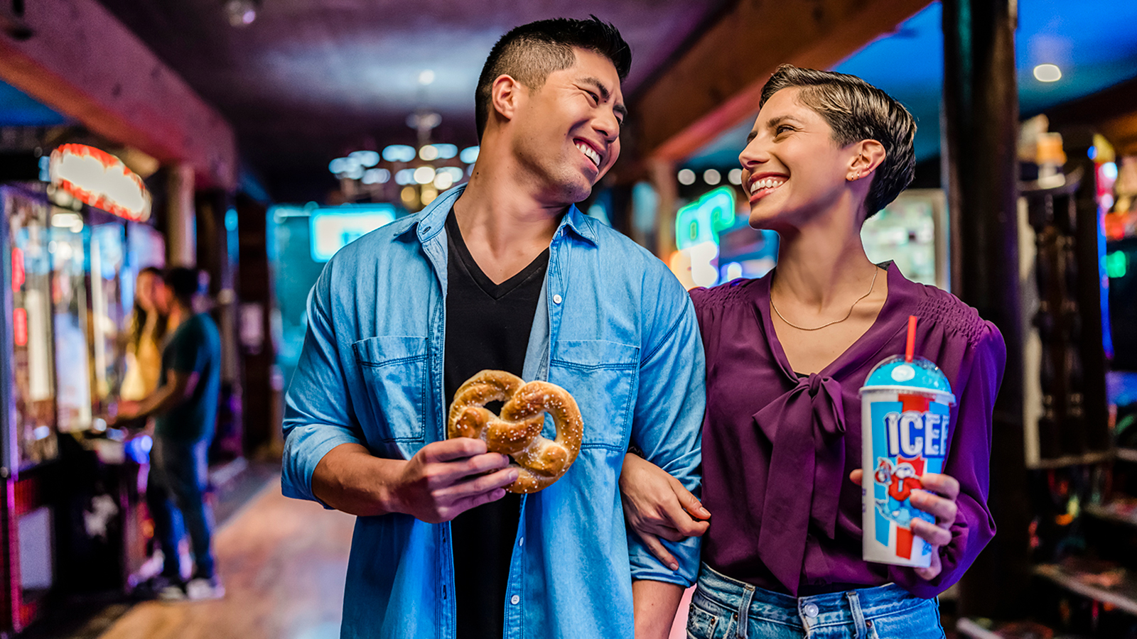 A couple enjoying J&J Snacks at an arcade