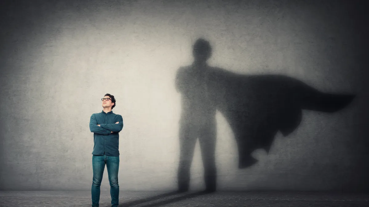 Individual Person standing in front of a superman shadow