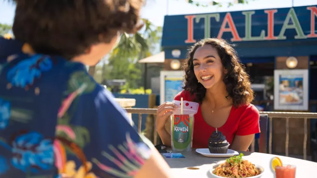 Beautiful girl enjoying a beverage and talking to a friend at SeaWorld Table