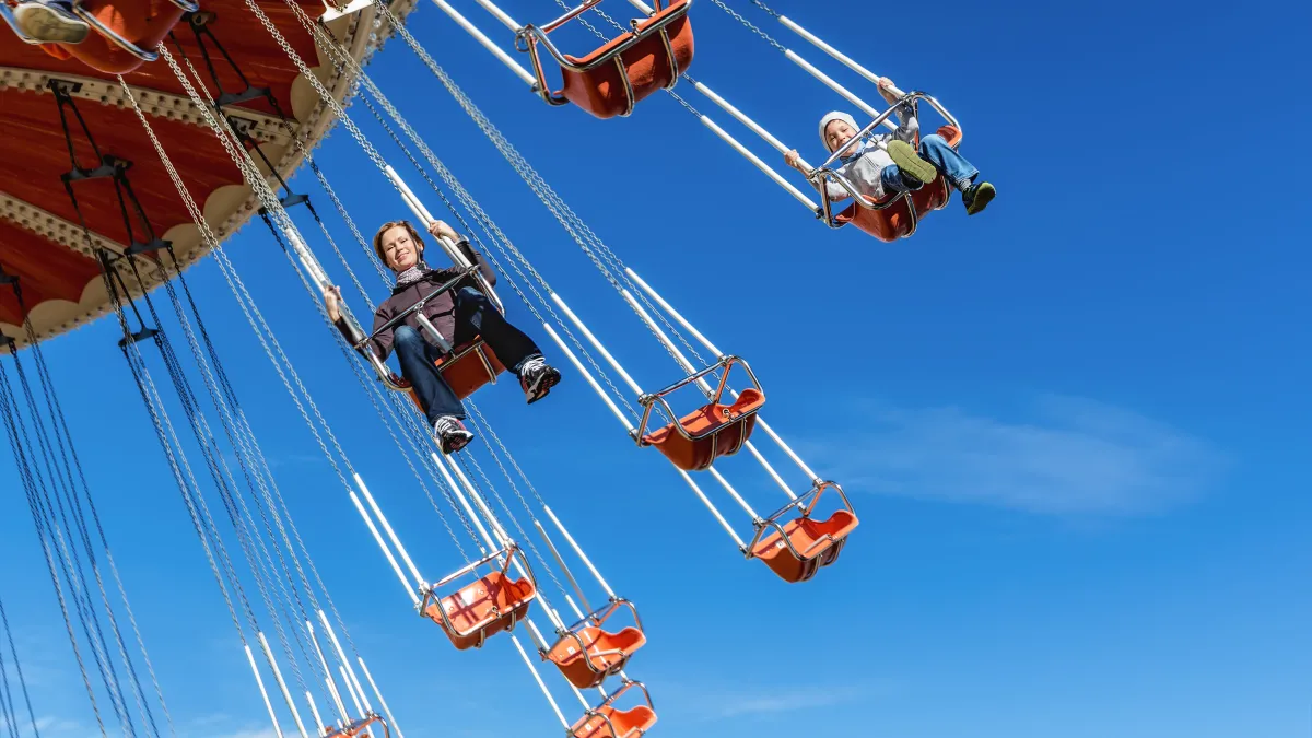 Adults riding on high swings