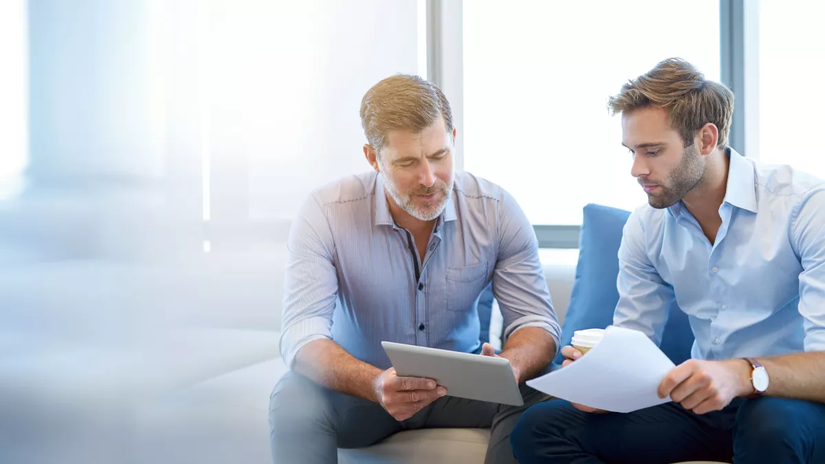 Older white man mentoring younger male employee