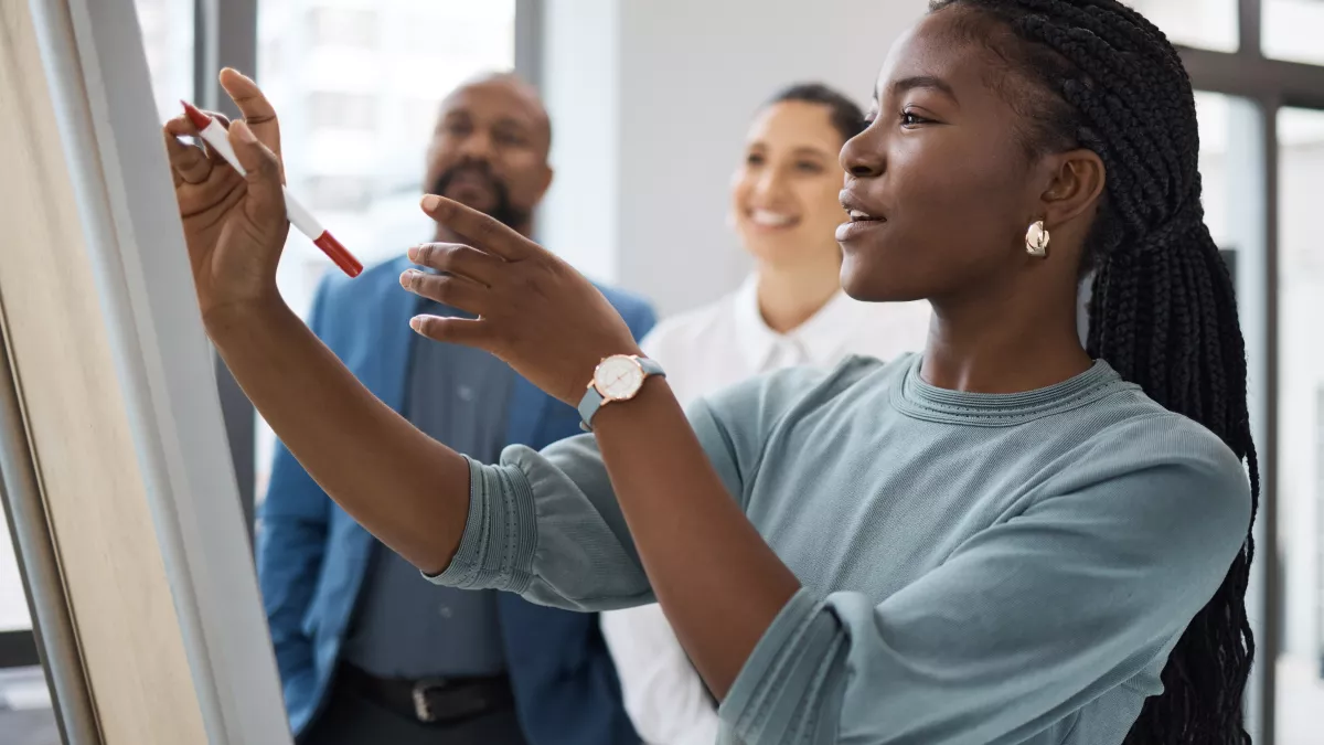 Black Female professional working on a whiteboard
