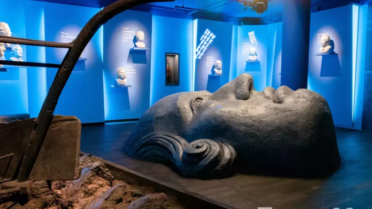 Oversized concrete face coming out of floor in museum