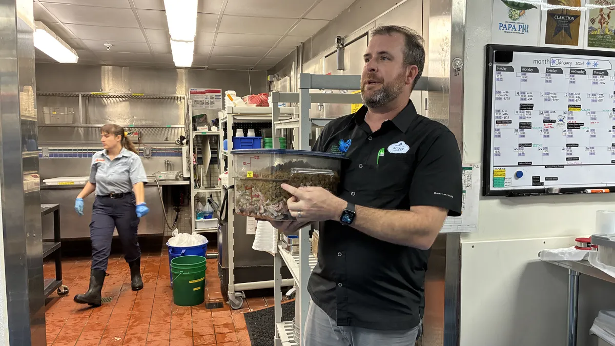 A Disney nutritionist holds a case of fish and squid
