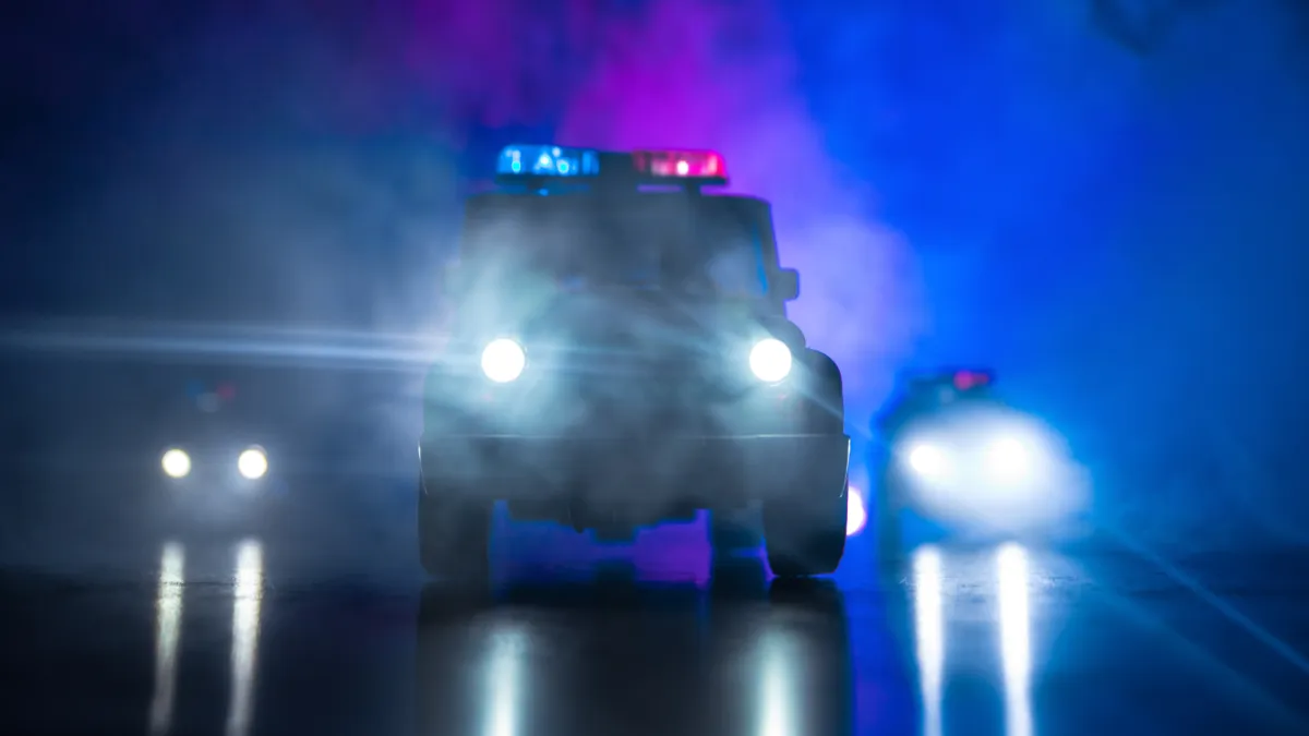 The police pull up outside a wet, dark facility