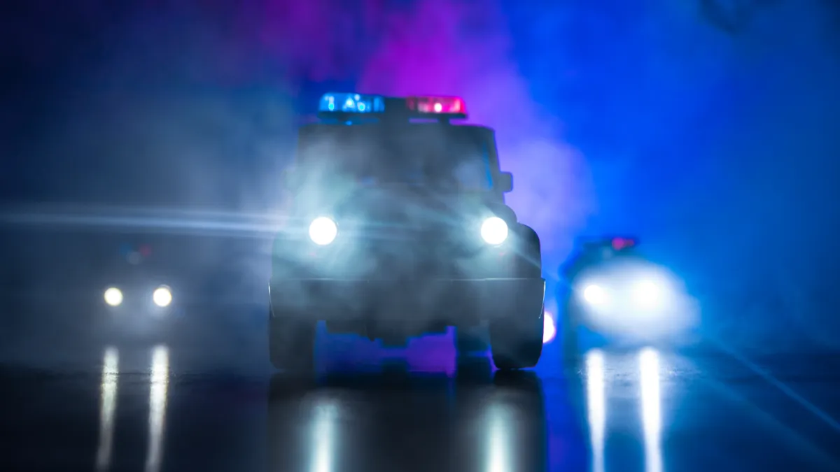 The police pull up outside a wet, dark facility