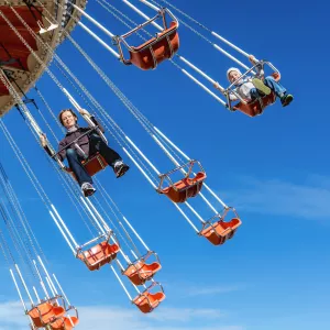 Adults riding on high swings