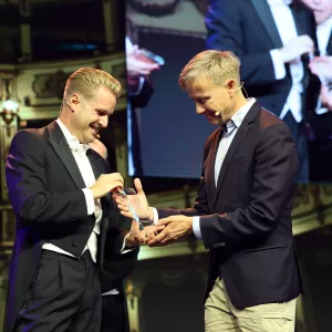 Peter Van Der Schans and Andreas Anderson looking at an award