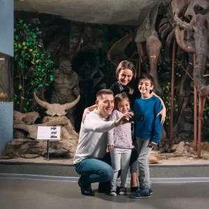 Family taking a photo with a dinosaur museum exhibit 