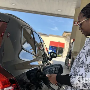 woman fueling a vehicle at the gas pump