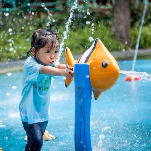 child playing in water splash pad