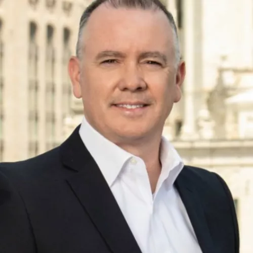 Man wearing white collared button down and black suit jacket