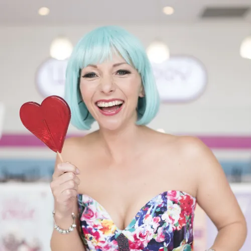 Natasha Erichsen smiling to camera holding a giant lollypop