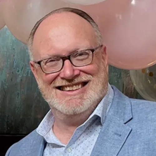 Man wearing glasses, smiling