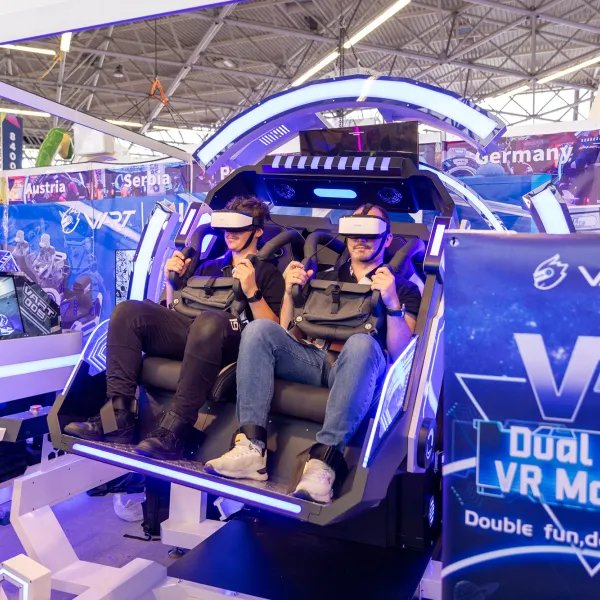 Attendees riding a VR Motion Simulator at IAAPA Expo