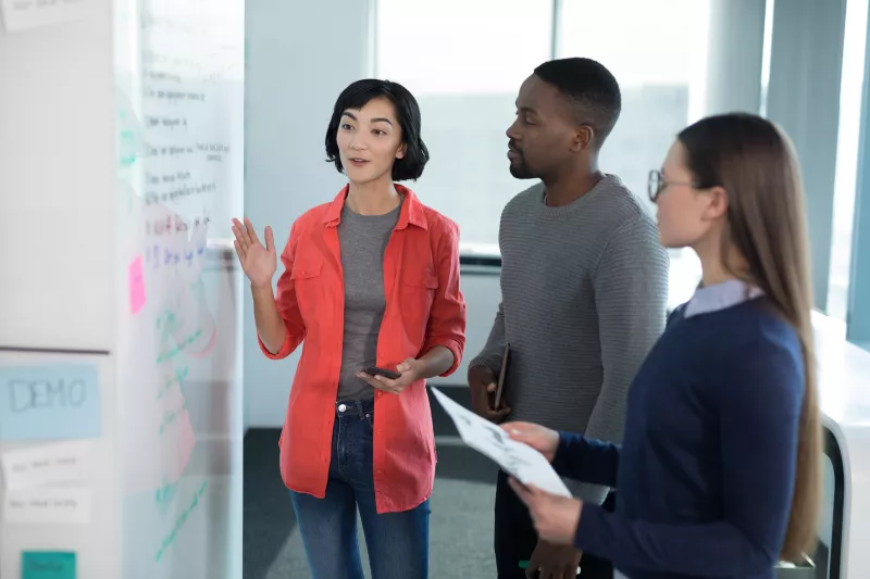 Male and Female executives collaborating on whiteboard