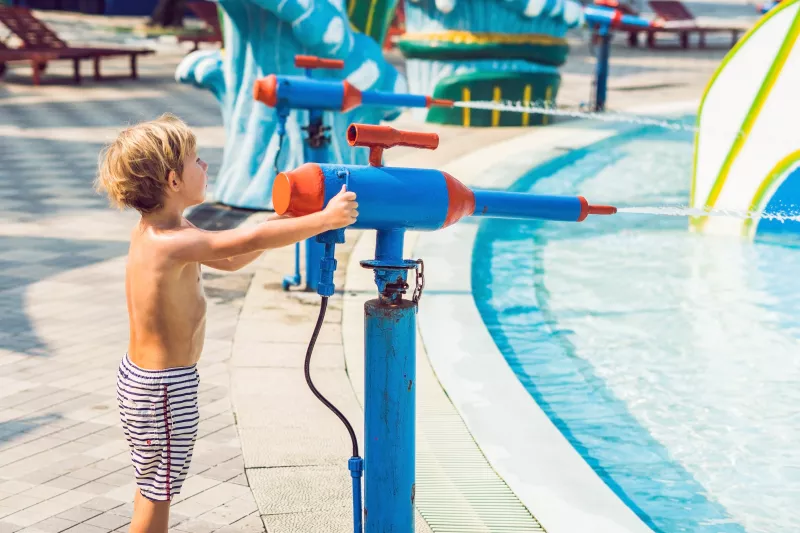 Boy using water shooter at water park