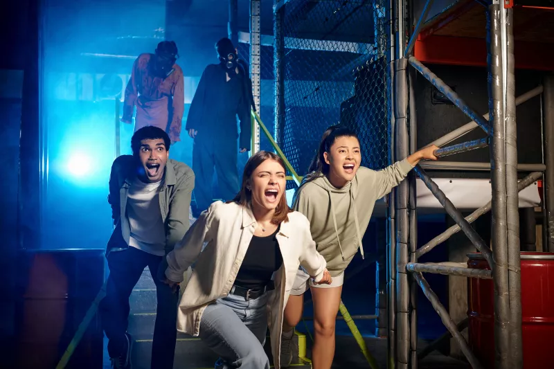 Multicultural friends running from an escape room