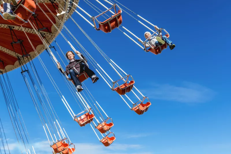 Adults riding on high swings