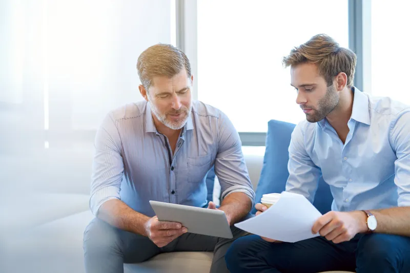 Older white man mentoring younger male employee
