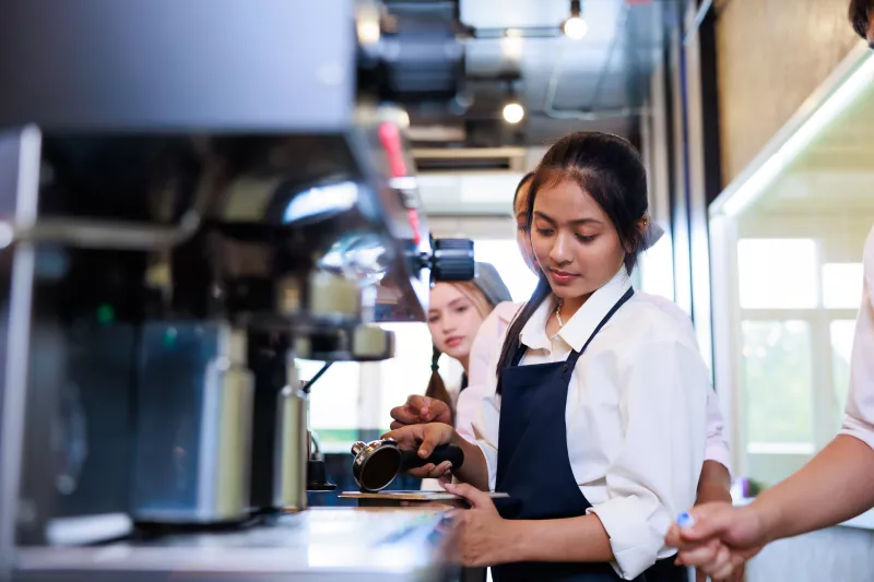 Barista learning to make coffee