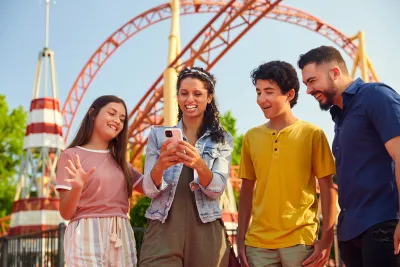 Family looking at phone during a theme park visit