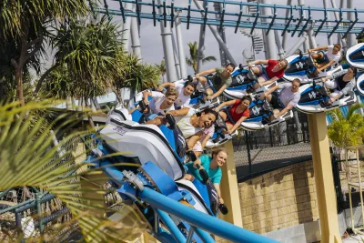 People riding a roller coaster themed to jet skis