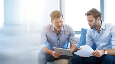Older white man mentoring younger male employee