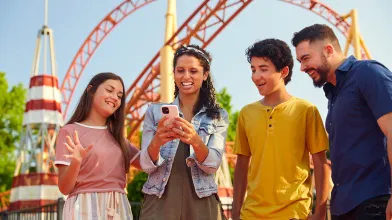 Family looking at phone during a theme park visit