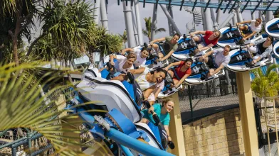 People riding a roller coaster themed to jet skis