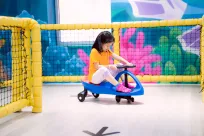 Girl riding a toy car
