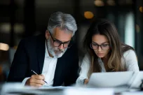 Seasoned male professional mentoring female colleague