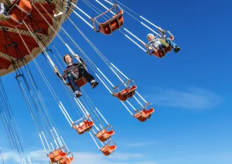 Adults riding on high swings