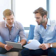 Older white man mentoring younger male employee