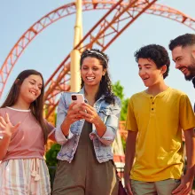Family looking at phone during a theme park visit