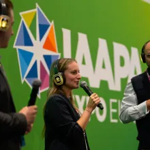 Speakers holding a microphone on stage at IAAPA Expo Europe 