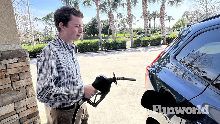 a male at the gas pump fuels a car